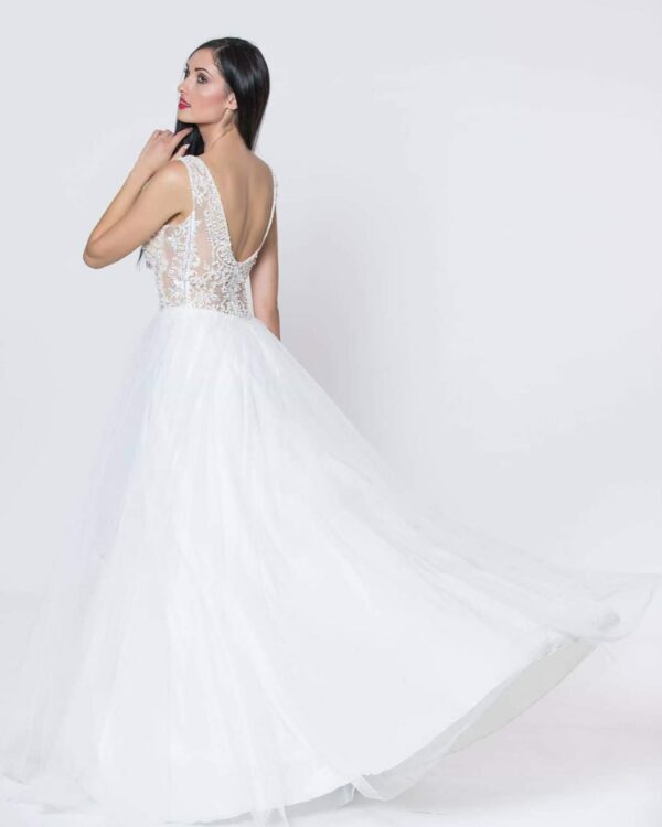 Εντυπωσιακό νυφικό με ολοκέντητο μπούστο με πέρλες και swarovski, με διαφάνεια soleil και ανοιχτή πλάτη.  Φούστα από μεταξωτό τούλι.