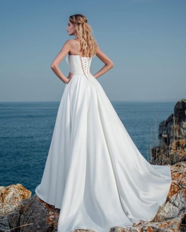 Στράπλες  νυφικό σε Άλφα γραμμή με  μπούστο κεντημένο με  υπέροχη γαλλική δαντέλα  και σατέν φούστα  με ουρά. Υπέροχο δέσιμο με κορδέλα στην πλάτη σε στυλ κορσέ.