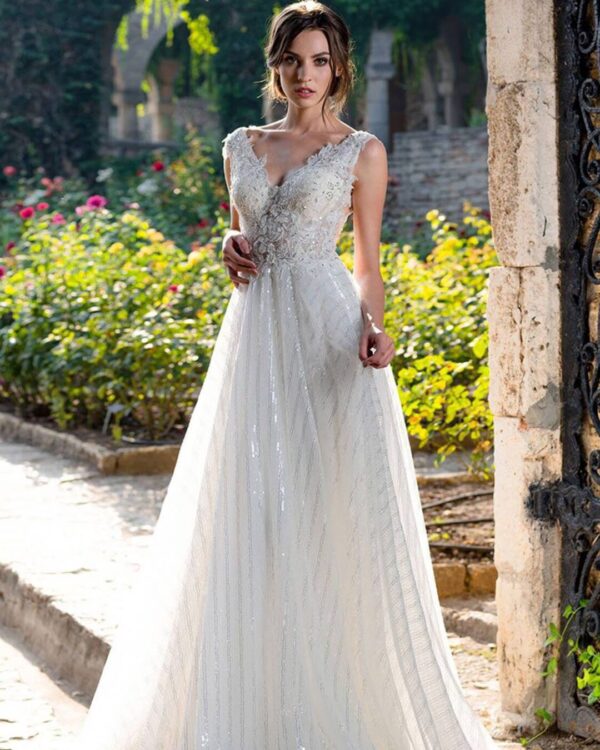 Πριγκηπικό νυφικό σε Άλφα γραμμή με  μπούστο κεντημένο με  υπέροχη γαλλική δαντέλα, διακοσμημένο με στρας και φούστα από γαλλικό τούλι με ρίζες ασημί για λάμψη . Μπούστο V με δαντέλα που αγκαλιάζει όμορφα τον ώμο