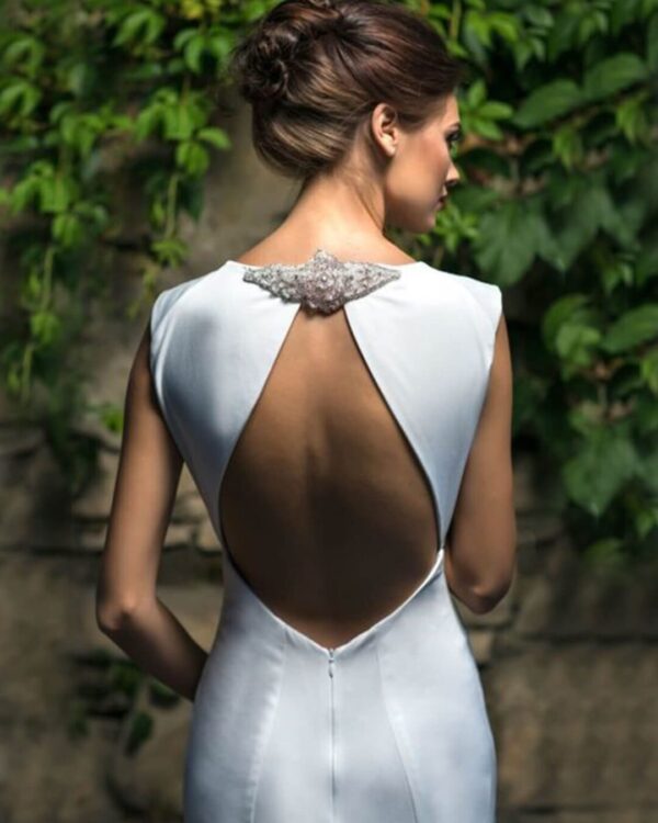 Ρομαντικό νυφικό σε Άλφα γραμμή με εντυπωσιακή πλάτη ανοιχτή σε σχήμα σταγόνας με δέσιμο ψηλά. Όλο από γαλλικό σατέν, με κλειστό μπούστο και εντυπωσιακή ουρά