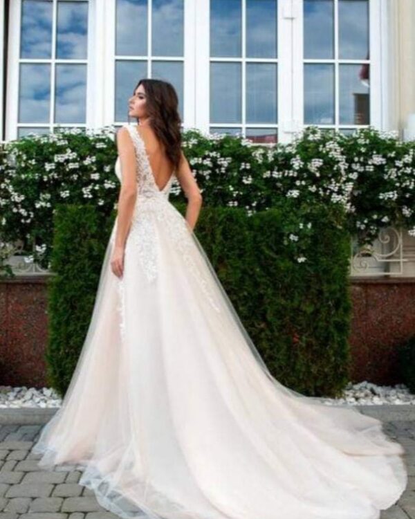 Εντυπωσιακό νυφικό σε Άλφα γραμμή με  μπούστο κεντημένο με  υπέροχη γαλλική δαντέλα και nude φούστα από γαλλικό τούλι, διακοσμημένη με δαντέλα κάτω από τη μέση. Υπέροχο μπούστο και πλάτη με βαθύ V. Ελληνικής ραφής