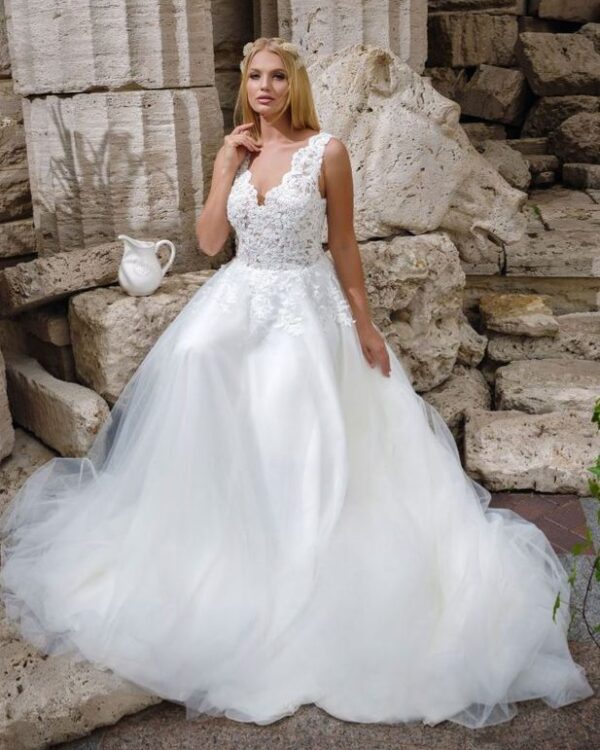 Ρομαντικό νυφικό σε Άλφα γραμμή, με φούστα από γαλλικό τούλι και κεντημένη δαντέλα κάτω από τη μέση. Με υπέροχο ολοκέντητο μπούστο με γαλλική δαντέλα που καταλήγει σε βαθύ V στην πλάτη και το μπούστο. Άνετη γραμμή. Ελληνικής ραφής