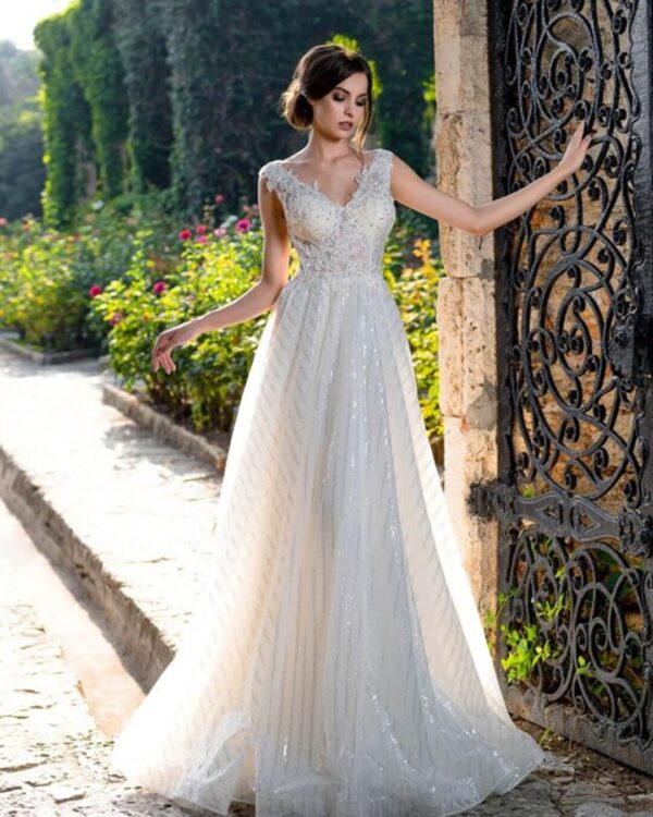 Πριγκηπικό νυφικό σε Άλφα γραμμή με  μπούστο κεντημένο με  υπέροχη γαλλική δαντέλα, διακοσμημένο με στρας και φούστα από γαλλικό τούλι με ρίζες ασημί για λάμψη . Μπούστο V με δαντέλα που αγκαλιάζει όμορφα τον ώμο