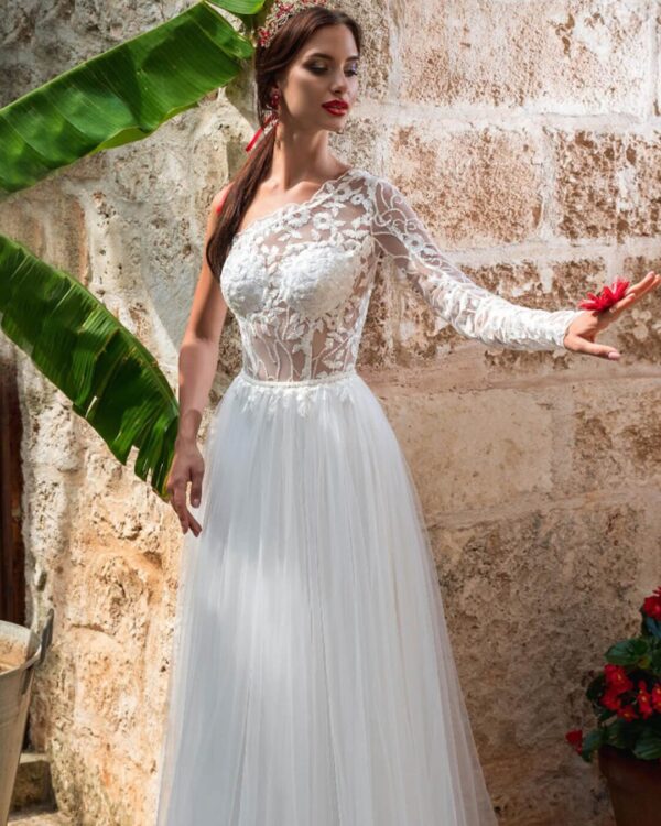 Εκκεντρικό νυφικό με ολοκέντητο μπούστο με γαλλική δαντέλα διαφάνεια soleil, με έναν ώμο και στενό μανίκι δαντέλα. Πλούσια φούστα από γαλλικό τούλι.