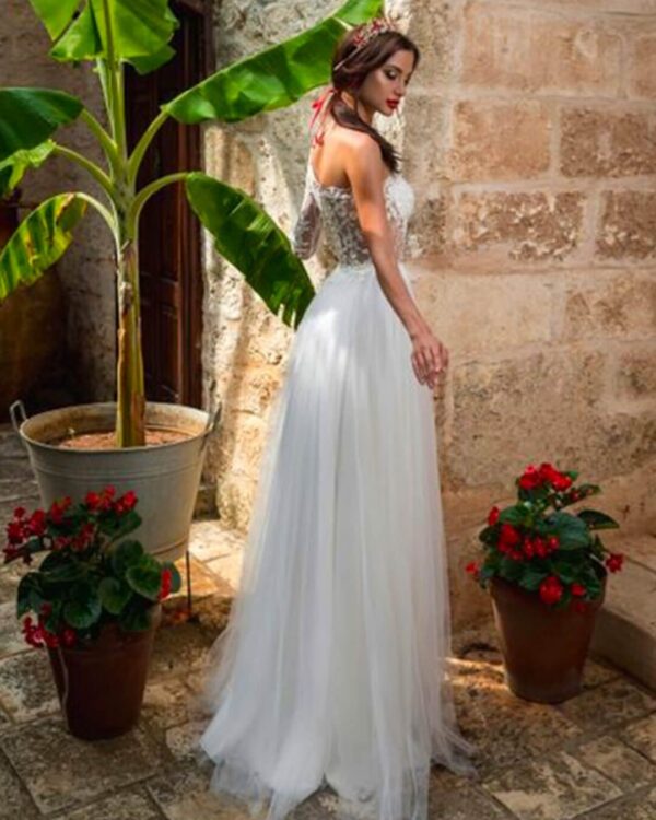 Εκκεντρικό νυφικό με ολοκέντητο μπούστο με γαλλική δαντέλα διαφάνεια soleil, με έναν ώμο και στενό μανίκι δαντέλα. Πλούσια φούστα από γαλλικό τούλι.