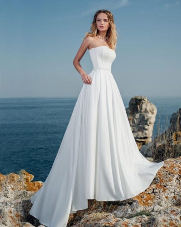 Στράπλες  νυφικό σε Άλφα γραμμή με  μπούστο κεντημένο με  υπέροχη γαλλική δαντέλα  και σατέν φούστα  με ουρά. Υπέροχο δέσιμο με κορδέλα στην πλάτη σε στυλ κορσέ.