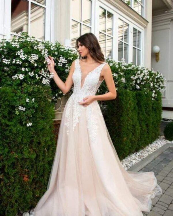 Εντυπωσιακό νυφικό σε Άλφα γραμμή με  μπούστο κεντημένο με  υπέροχη γαλλική δαντέλα και nude φούστα από γαλλικό τούλι, διακοσμημένη με δαντέλα κάτω από τη μέση. Υπέροχο μπούστο και πλάτη με βαθύ V. Ελληνικής ραφής