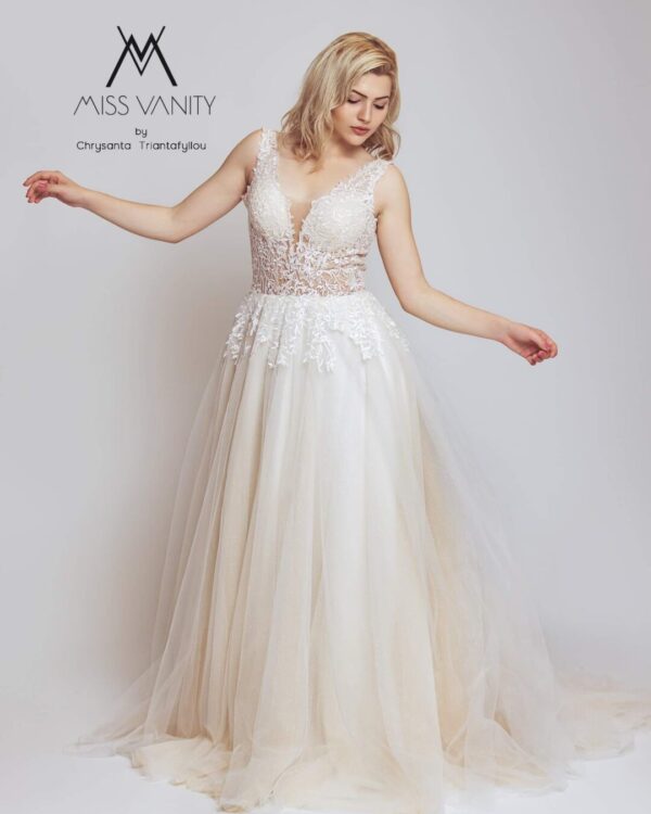 Εντυπωσιακό νυφικό με διαφάνεια στο μπούστο και κεντημένο με ανάγλυφη γαλλική δαντέλα. Φούστα σε άλφα γραμμή, από γαλλικό τούλι σε λευκό με νερά στο χρώμα της πούδρας. Ανοιχτή πλάτη σε βαθύ V. 