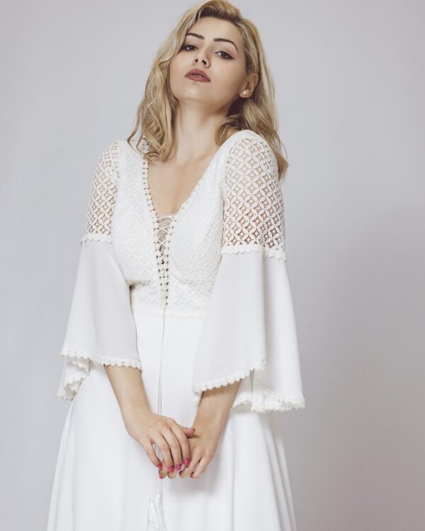 Boho chic νυφικό φόρεμα σε κρεπ, με ανάγλυφη βαμβακερή δαντέλα στο μπούστο και το μανίκι, σε άλφα γραμμή, ψιλόμεσο. Αέρινο μανίκι. Κανονική εφαρμογή.  Ιδανικό για πολιτικό γάμο αλλά και σε εκκλησία!