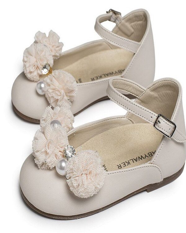 Χειροποίητα βαπτιστικά παπουτσάκια μπαλαρίνες σε εκρού δέρμα με διακοσμητικά λουλουδάκια από τούλι και στρας. Ανατομικός δερμάτινος πάτος κατάλληλος για τα πρώτα βήματα του παιδιού. Ελληνικής ραφής