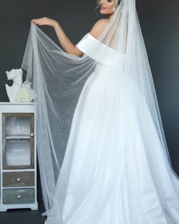 Εντυπωσιακό Πριγκιπικό νυφικό από μετάξι Mikado σε Άλφα γραμμή. Έξωμο με μπούστο V και διαφάνεια soleil. Κανονική εφαρμογή