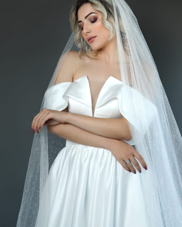 Εντυπωσιακό Πριγκιπικό νυφικό από μετάξι Mikado σε Άλφα γραμμή. Έξωμο με μπούστο V και διαφάνεια soleil. Κανονική εφαρμογή