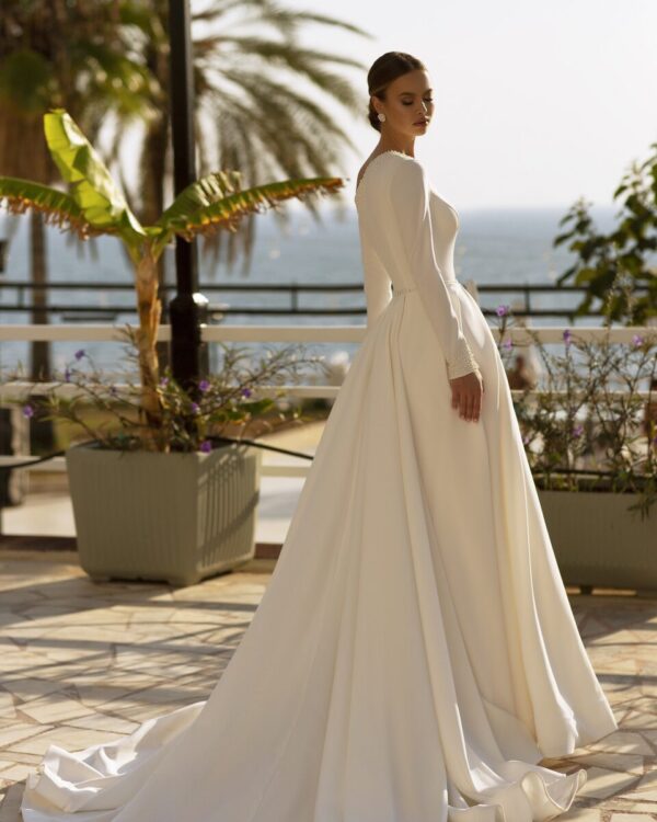 Εντυπωσιακό νυφικό με μανίκι και υπέροχο άνοιγμα στον ώμο σε ιβουάρ