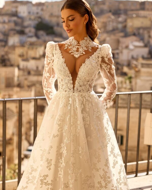 Νυφικό φόρεμα δαντέλα με βαθύ ντεκολτέ, μανίκια και ανοιχτή πλάτη.