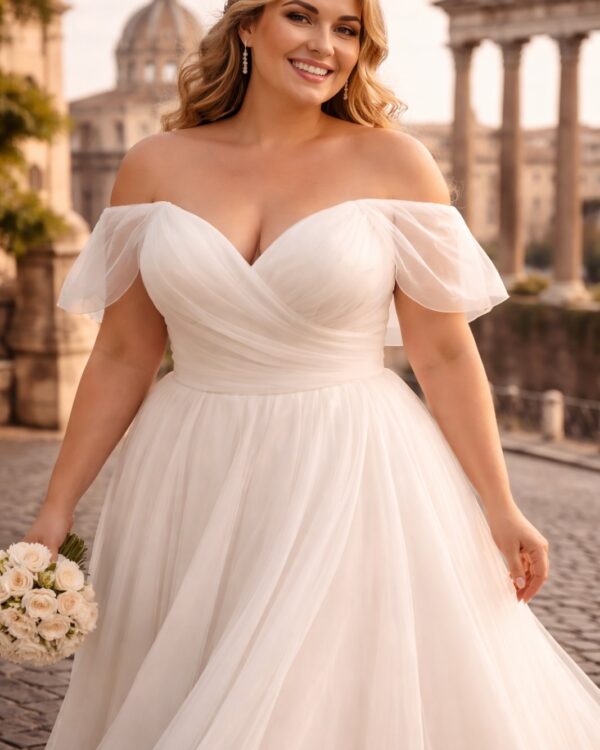 Bride in a flowing off-shoulder white wedding dress holding a bouquet, standing on a cobblestone path with historic pillars in the background.