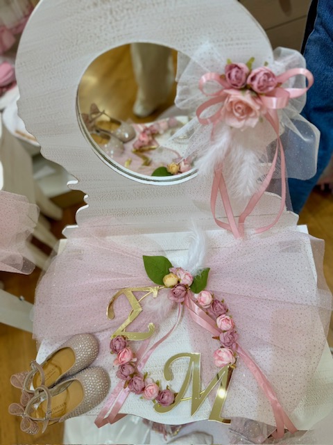 oloklhrwmeno paketo baptishs me ksulino mpoudouar(3) Decorative pink wedding vanity with tulle, roses, ribbons, and gold letters 'T' and 'M' beside miniature shoes in a mirror box.