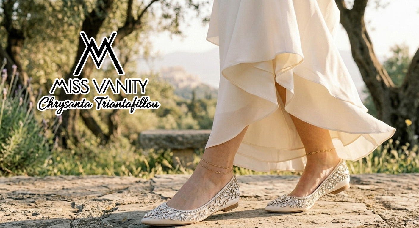 Miss Vanity logo over a model wearing bejeweled beige flats walking on a sunlit stone path in a flowing cream dress with greenery in the background.