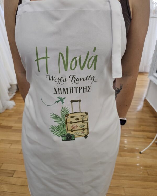 Apron with green 'H Nova' and 'World Traveller' text, Greek name Δημητρης, and travel-themed drawing of a suitcase, palm leaves, camera, and a small airplane.