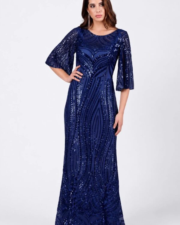 Woman in a navy blue sequin floor-length gown with short puff sleeves, posing with hand on hip
