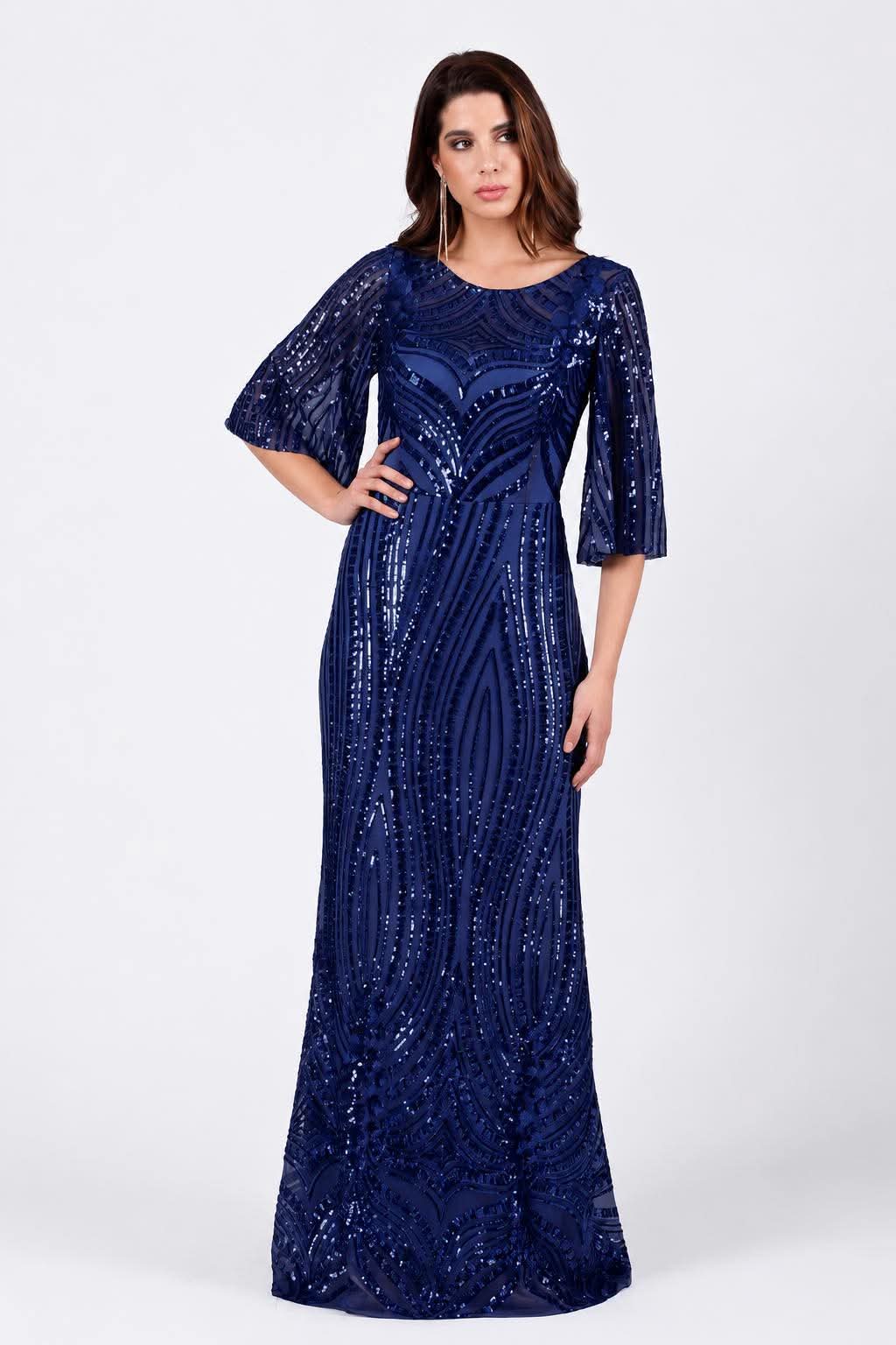 maxi forema me gewmetrikes pagietes kai aerina manikia(2)pagiet Woman in a navy blue sequin floor-length gown with short puff sleeves, posing with hand on hip