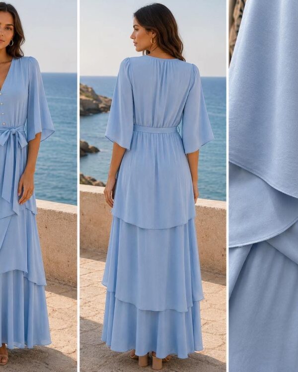 Woman wearing a light blue flutter-sleeve wrap maxi dress by the sea, with a waist tie and layered skirt.