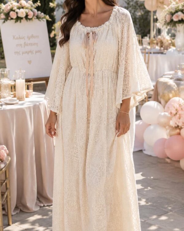 Smiling woman in a cream lace maxi dress at an outdoor wedding reception with pink and white balloons.