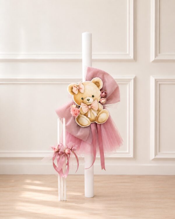 Decorative white candle adorned with a plush teddy bear, pink bows, and pink tulle ribbons for a baby or celebration setting.