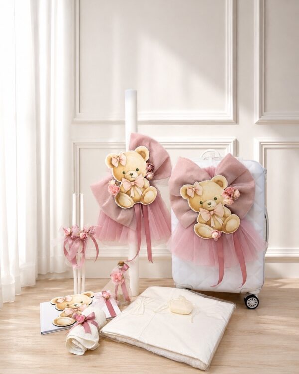 Pastel pink teddy bear decorations with bows and tulle draped on a white suitcase in a bright room.